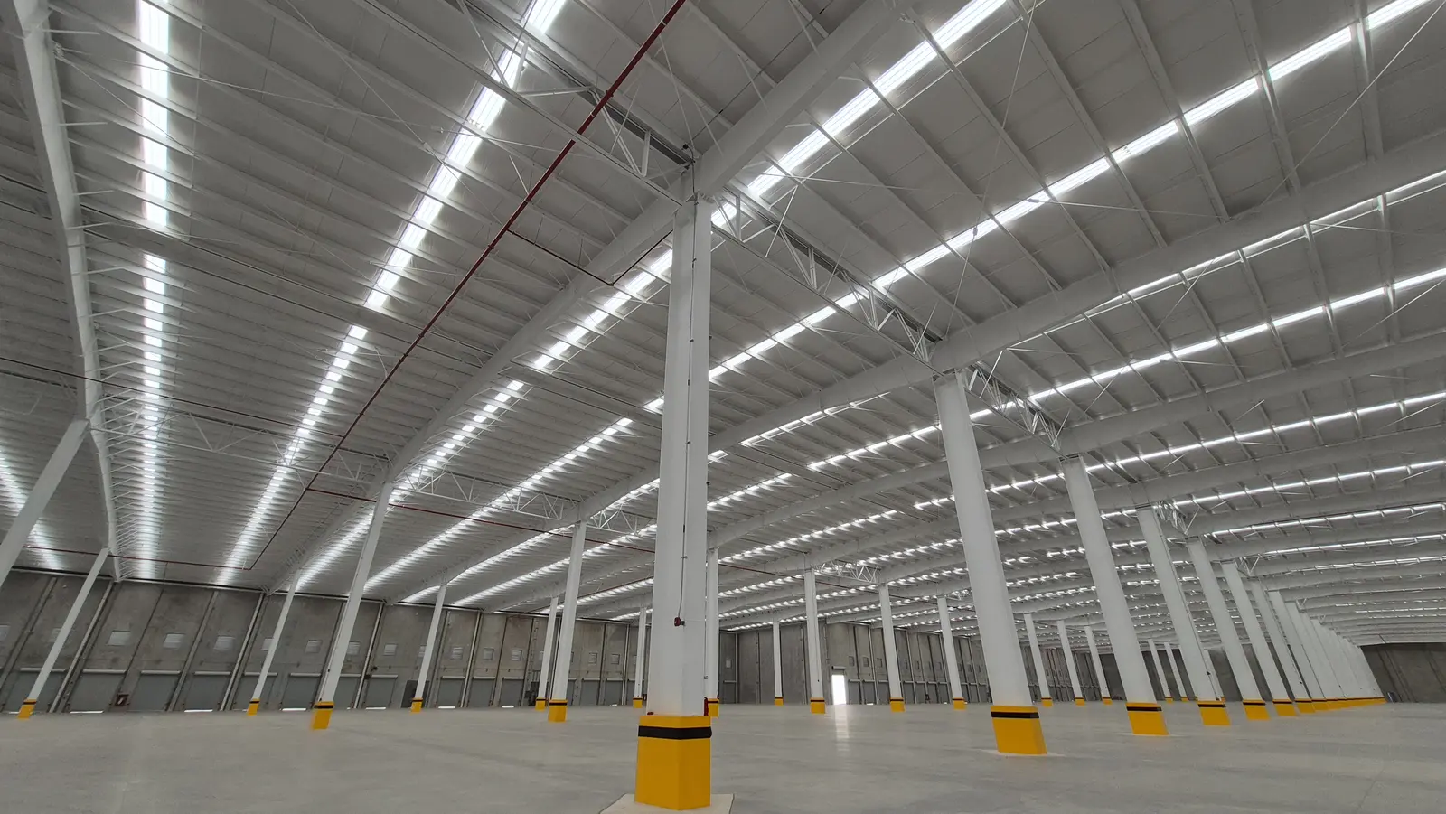 Interior de nave industrial con láminas traslúcidas para iluminación natural y luminarias LED